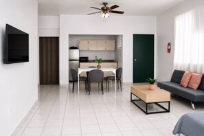 Ein modernes Wohnzimmer mit Sofa, Couchtisch und Fernseher.