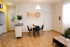 A modern kitchen with a dining area, a clock on the wall, and a fire extinguisher. - Spacious Budget-Friendly 1BR by Escambron Beach (San Juan)