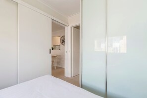 Een slaapkamer met een bed, een kledingkast en een deur naar een badkamer.