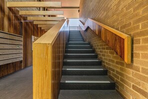 Eine Treppe mit Holheitslaufgeländern und einer Ziegelwand.