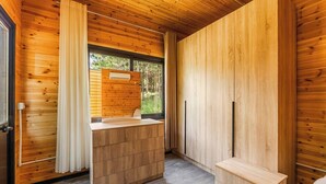 Un intérieur en bois avec un banc intégré, une fenêtre avec des rideaux et une porte.