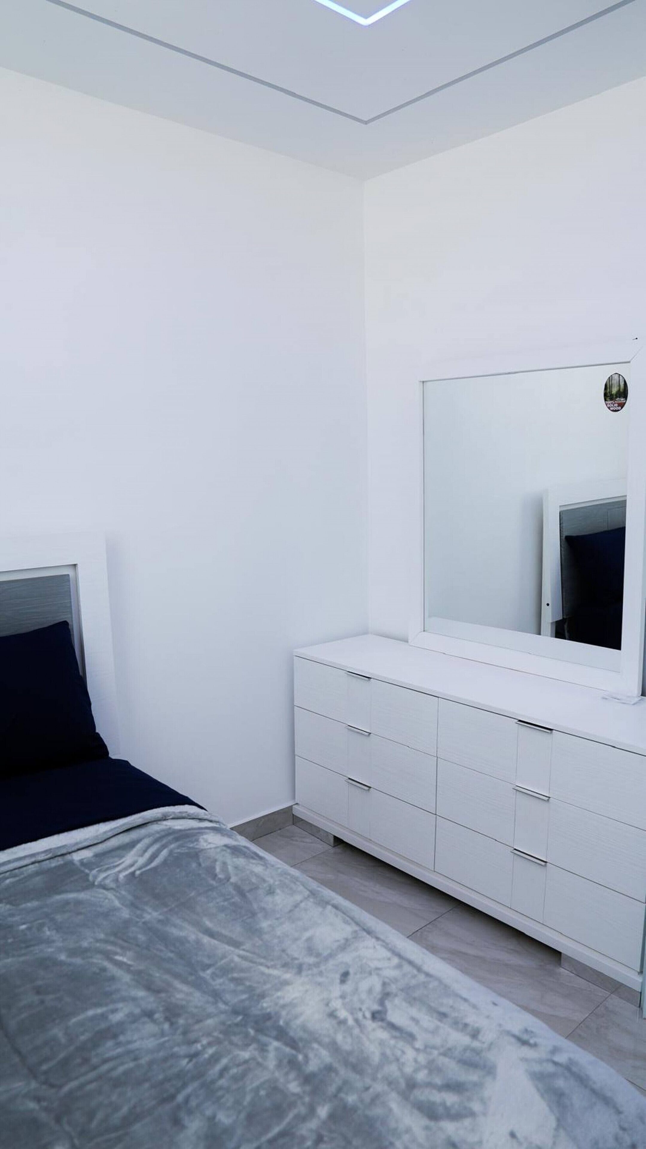 Ein Schlafzimmer mit einem Bett, einem Schminktisch und einem Spiegel.