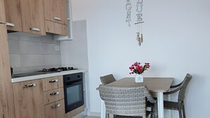 Una cucina moderna con mobili in legno, un tavolo da pranzo con sedie in vimini e un lampadario.