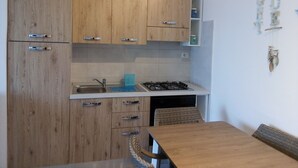 Una cucina con mobili in legno, un fornello a gas e un lavello.