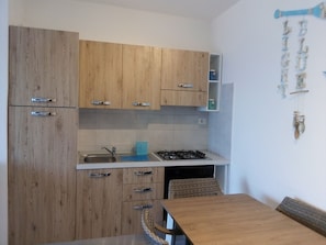 Eine Küche mit Holzausstattung, einem Gasherd und einem Spülbecken.