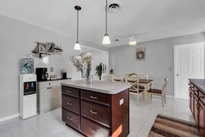 A modern kitchen with a central island, a coffee machine, and a water dispenser. - Relaxed Ocean Gate Shore Getaway 3BR + Fireplace (Ocean Gate)