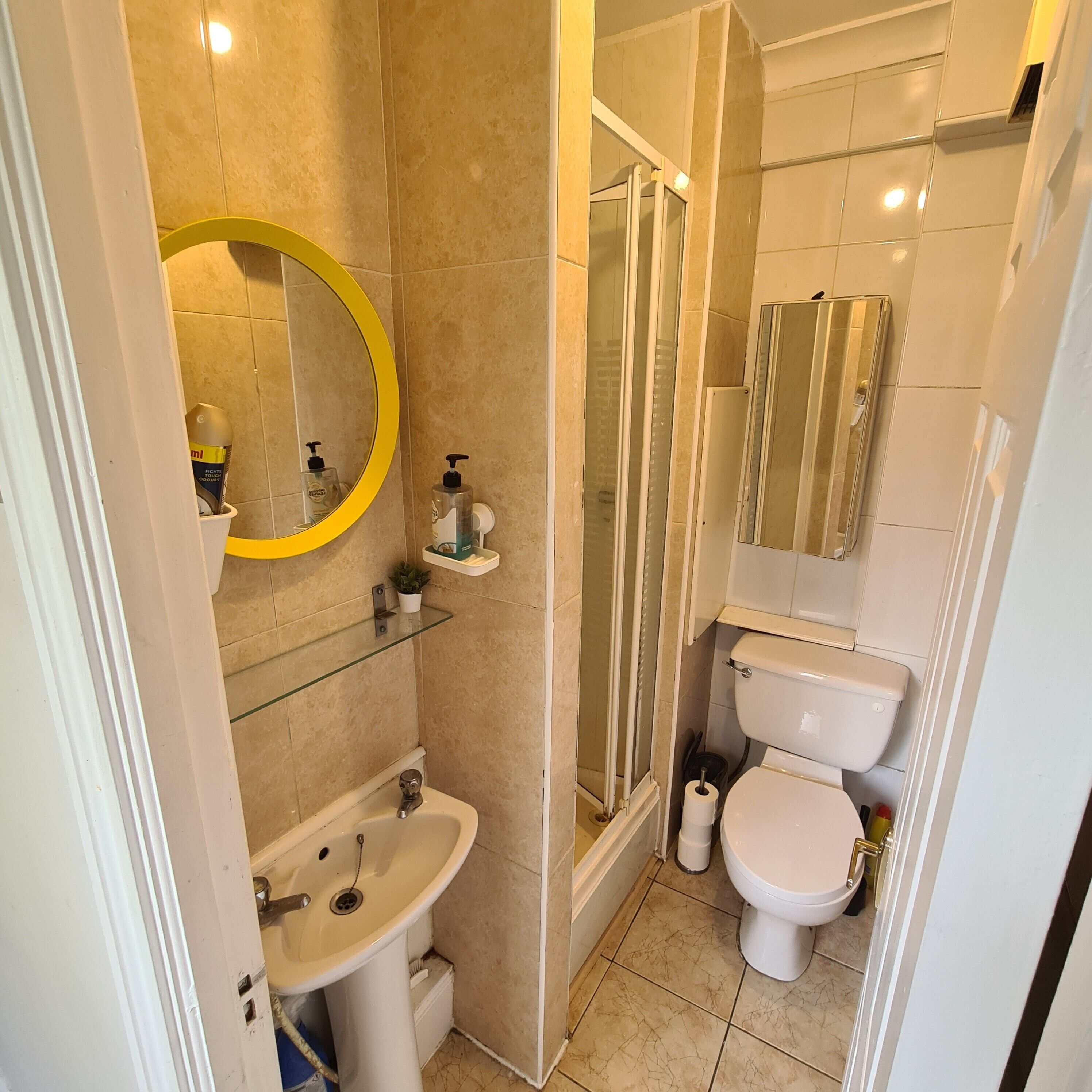 A bathroom with a sink, toilet, and shower area.