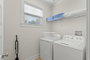 A laundry room with a washing machine, dryer, and a window with blinds. - Sleeps 10 l 3 Min to Beach l Pool l Game Room l Wireless Internet l Pompano Joes (Miramar Beach)