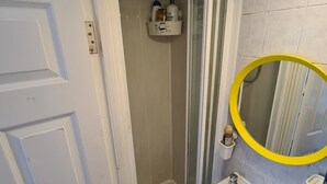Un baño con ducha, lavabo y espejo.