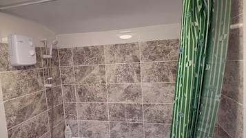 A bathroom with a bathtub, shower, and a toilet.