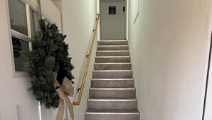 A staircase with wooden steps leading to a door with a sign.