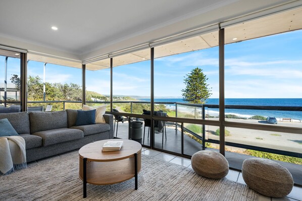 A modern living room with a large window overlooking a coastal view. - Carrickalinga House A Symphony of Sea and Serenity (Carrickalinga)