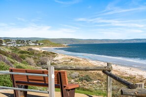 A coastal view with a wooden bench overlooking a beach and ocean. - Carrickalinga House A Symphony of Sea and Serenity (Carrickalinga)