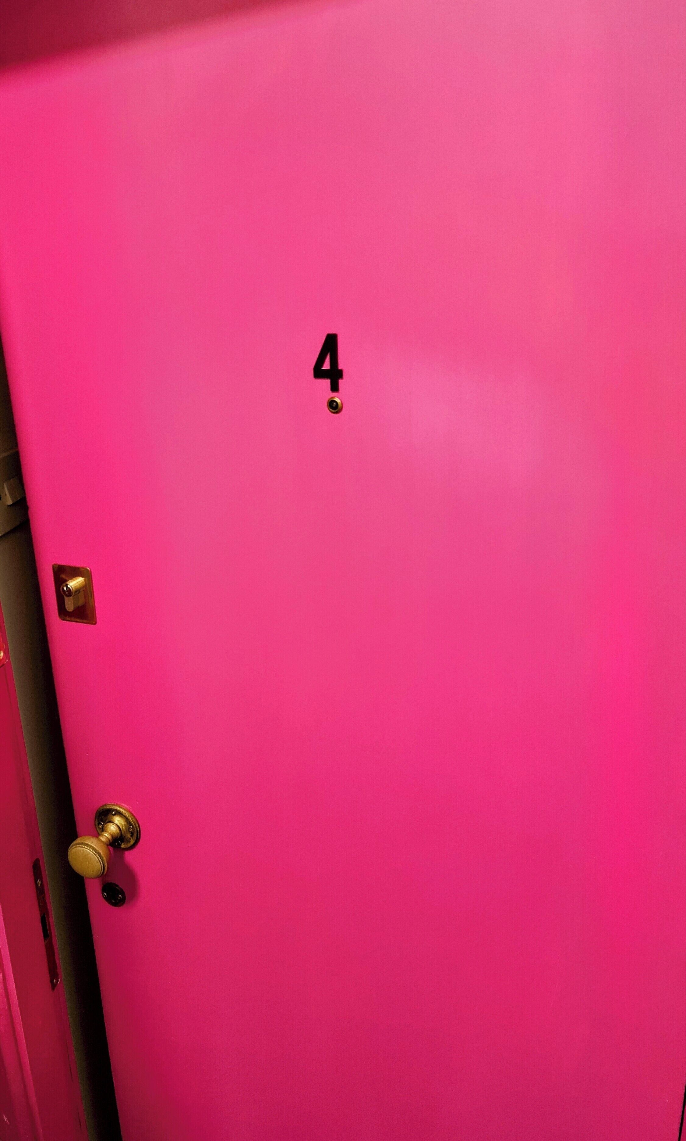 Una porta rosa con il numero 4 e una serratura.