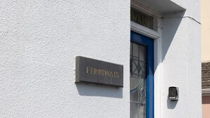 A building facade with a sign reading 'FERRIWAIIS' mounted on a textured wall. - Quayside retreat with stunning estuary views (Appledore)