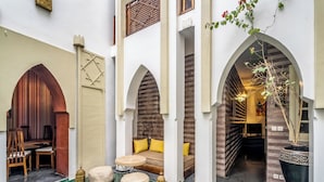 Un patio con una zona de estar, un banco de madera y una planta en maceta.
