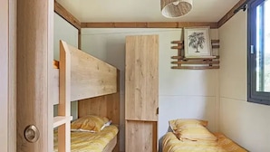 A compact room with bunk beds and a small window.