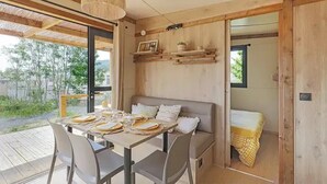 A cozy dining area with a table set for four, a sofa, and a hanging light fixture.