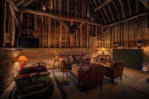 A rustic room with exposed wooden beams, a vintage Supercar model, a Game Zone sign, and a stone wall. - Beautiful Cottage with Tennis Court and Games Barn (Hambleden)