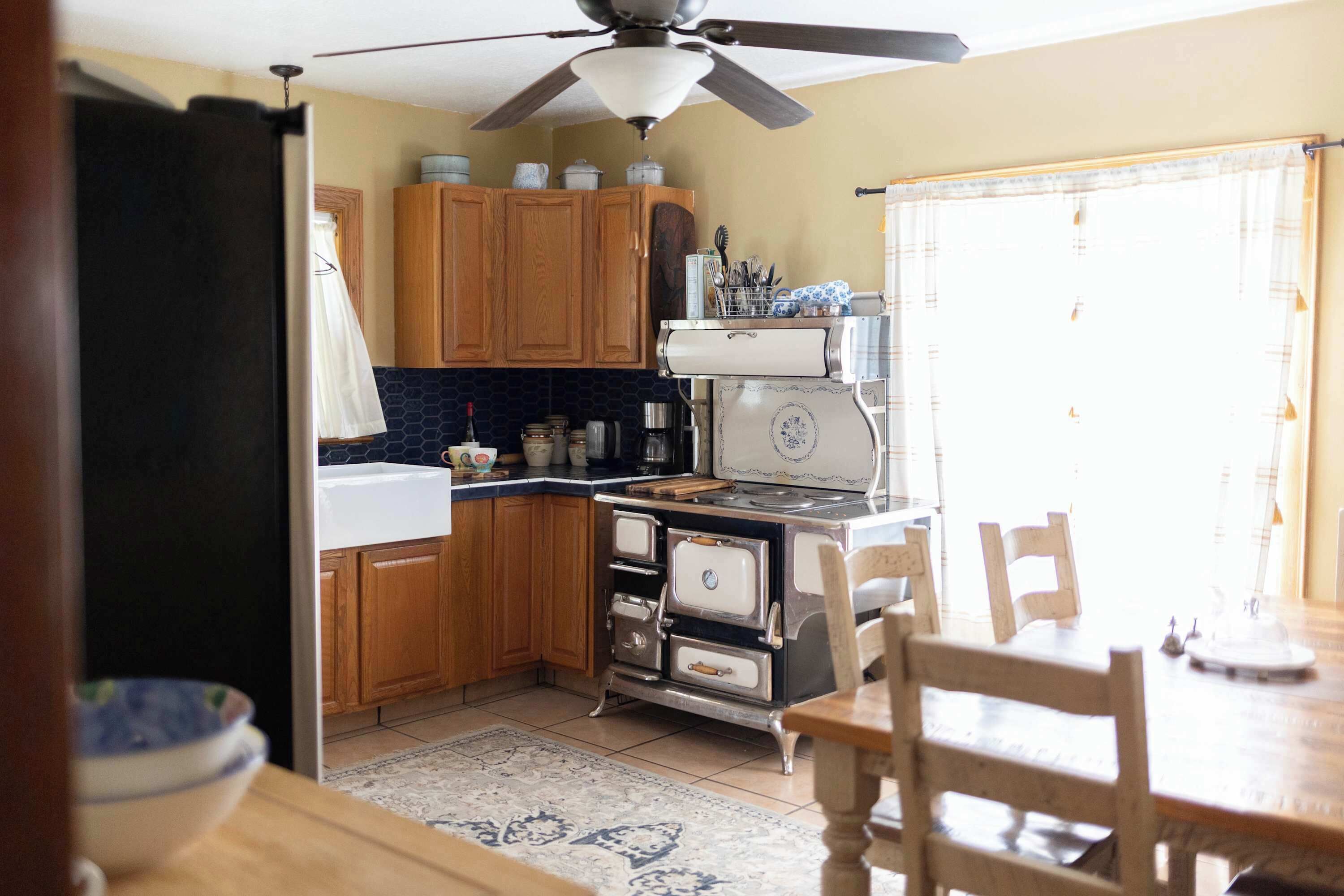 A kitchen with wooden cabinets, a stove, and a dining table.