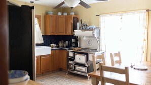 A kitchen with wooden cabinets, a stove, and a dining table.