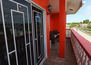 A balcony with a red railing, a glass door, and two chairs. - Amazing 3-bedroom apartment with AC in charming Georgetown (Georgetown)