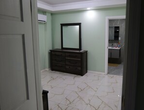 A bathroom with a dark wooden dresser, a mirror, and a tiled floor. - Amazing 3-bedroom apartment with AC in charming Georgetown (Georgetown)
