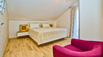 Une chambre à coucher avec un lit, une table de chevet, une chaise et une fenêtre avec des rideaux.