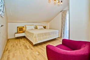A bedroom with a bed, a nightstand, a chair, and a window with curtains. - Spacious 5-bedroom apartment in marvelous Milna Hvar with AC (Milna Hvar)