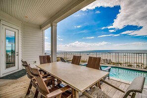 A covered outdoor area with a pool, a table with chairs, and a view of the beach. - Beachfront Bliss Beach House (Orange Beach)