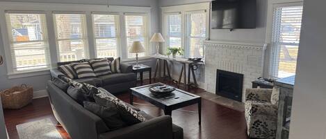 A living room with a sofa, coffee table, and fireplace.