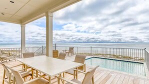 A covered outdoor area with a pool, a table, and chairs. - Beach Vista One Beach House (Orange Beach)