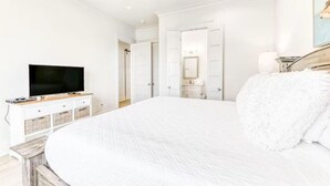 A bedroom with a large bed, a television, a dresser, and a wardrobe. - Beach Vista One Beach House (Orange Beach)