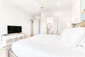 A bedroom with a large bed, a television, a dresser, and a wardrobe. - Beach Vista One Beach House (Orange Beach)