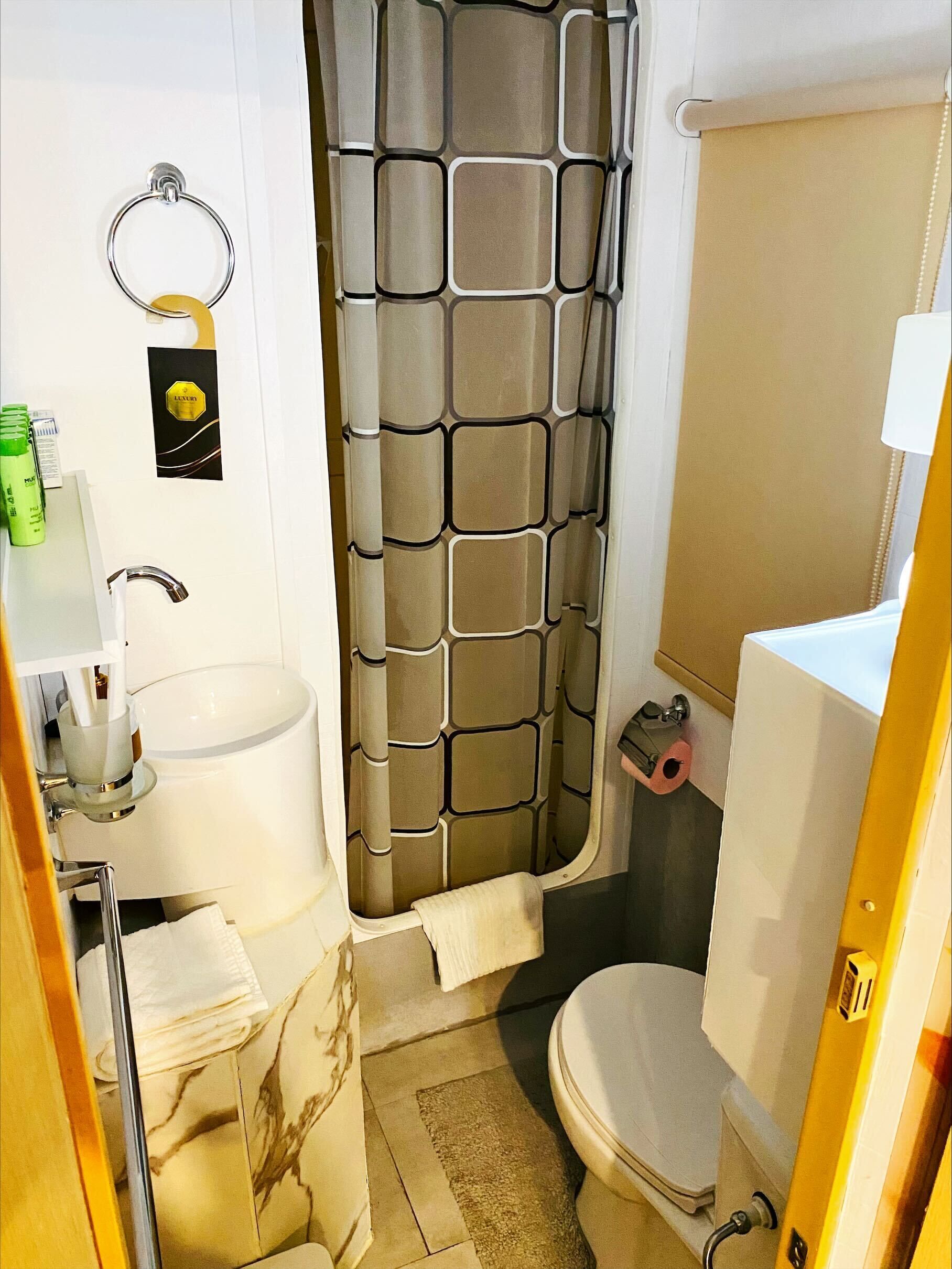 Un baño con inodoro, lavamanos y cortina de ducha.