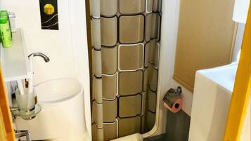 Un baño con inodoro, lavamanos y cortina de ducha.