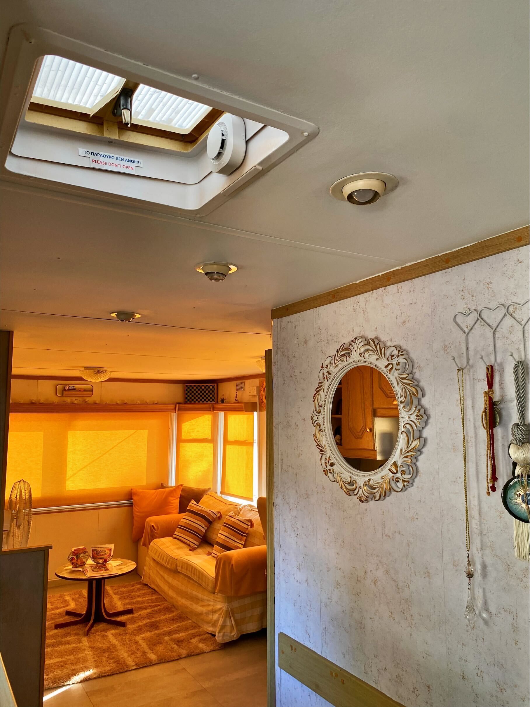 A room with a bed, a round mirror, and a small table.