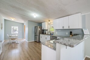 A modern kitchen with white cabinets, a granite countertop, and a built-in refrigerator. - Spacious Waterfront Home on Smith Mountain Lake (Moneta)