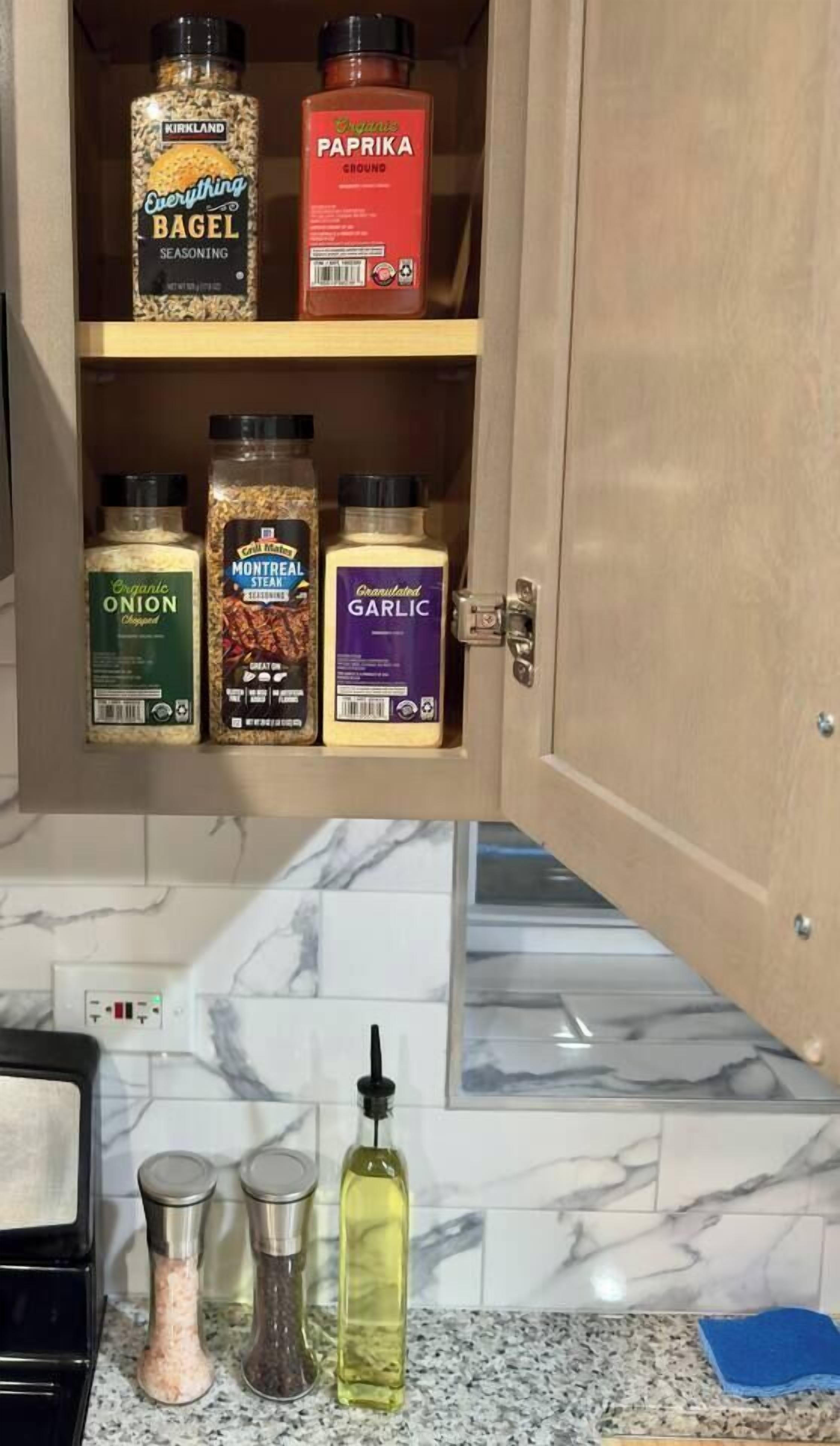 Un pensile della cucina con diverse bottiglie di spezie.