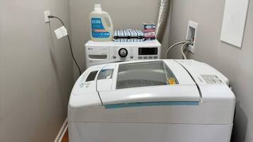 A laundry area with a front-loading washing machine, a dryer, and a water heater.