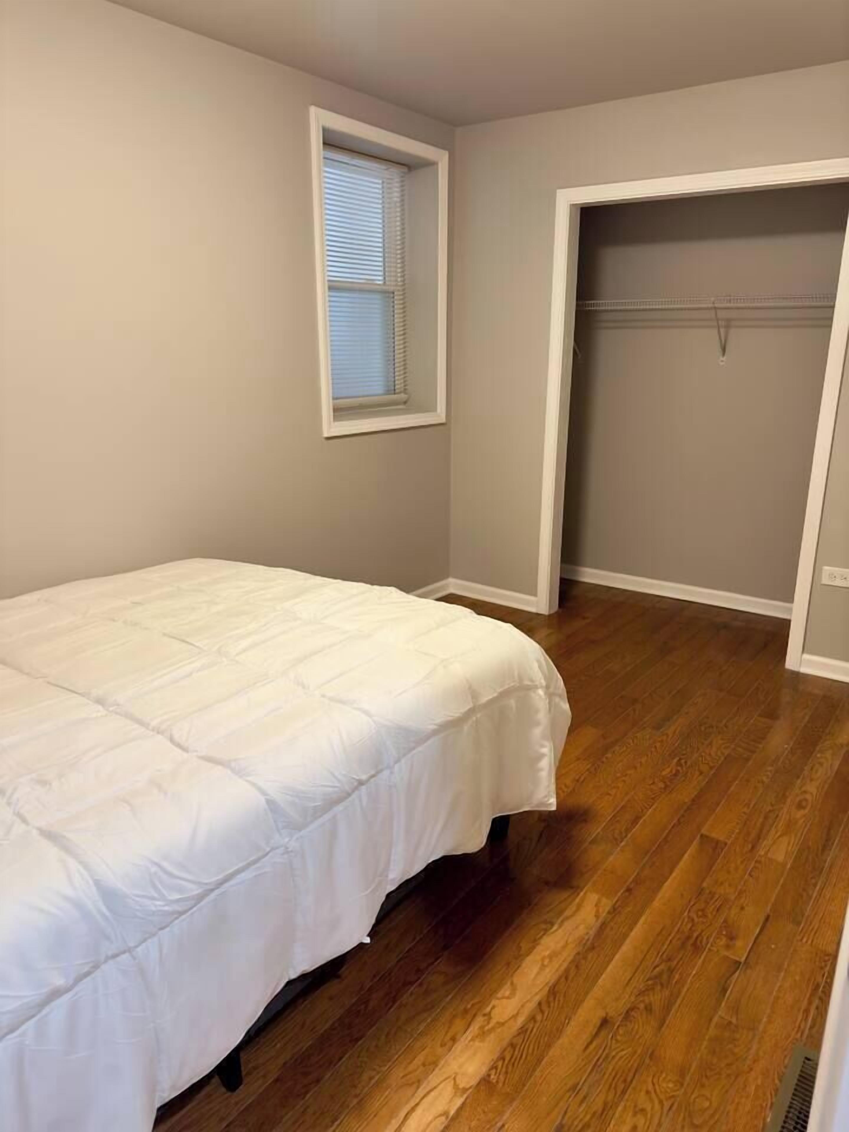 Une chambre à coucher avec un lit, une fenêtre et un dressing.