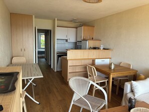 A compact living space with a kitchenette, dining area, and a separate sleeping area. - Appartement plage et vue mer (Quiberon)