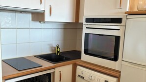 Eine Küche mit Geschirrspüler, Backofen und Spüle.
