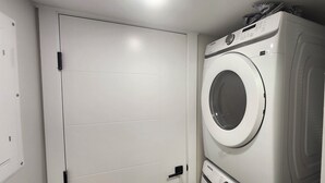 Een wasserette met een witte deur en een Samsung wasmachine.