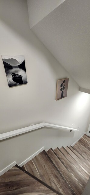 A staircase with wooden steps leading to a landing. - Newly constructed Cozy and spacious one bedroom legal basement suite-East Regina (Regina)