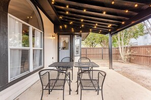 An outdoor patio with a covered seating area, a table, and chairs. - Spacious 3BR · Private Patio · Near Austin (Pflugerville)