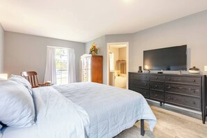 A bedroom with a bed, a dresser, a television, and a window with curtains. - Spacious 3BR · Private Patio · Near Austin (Pflugerville)