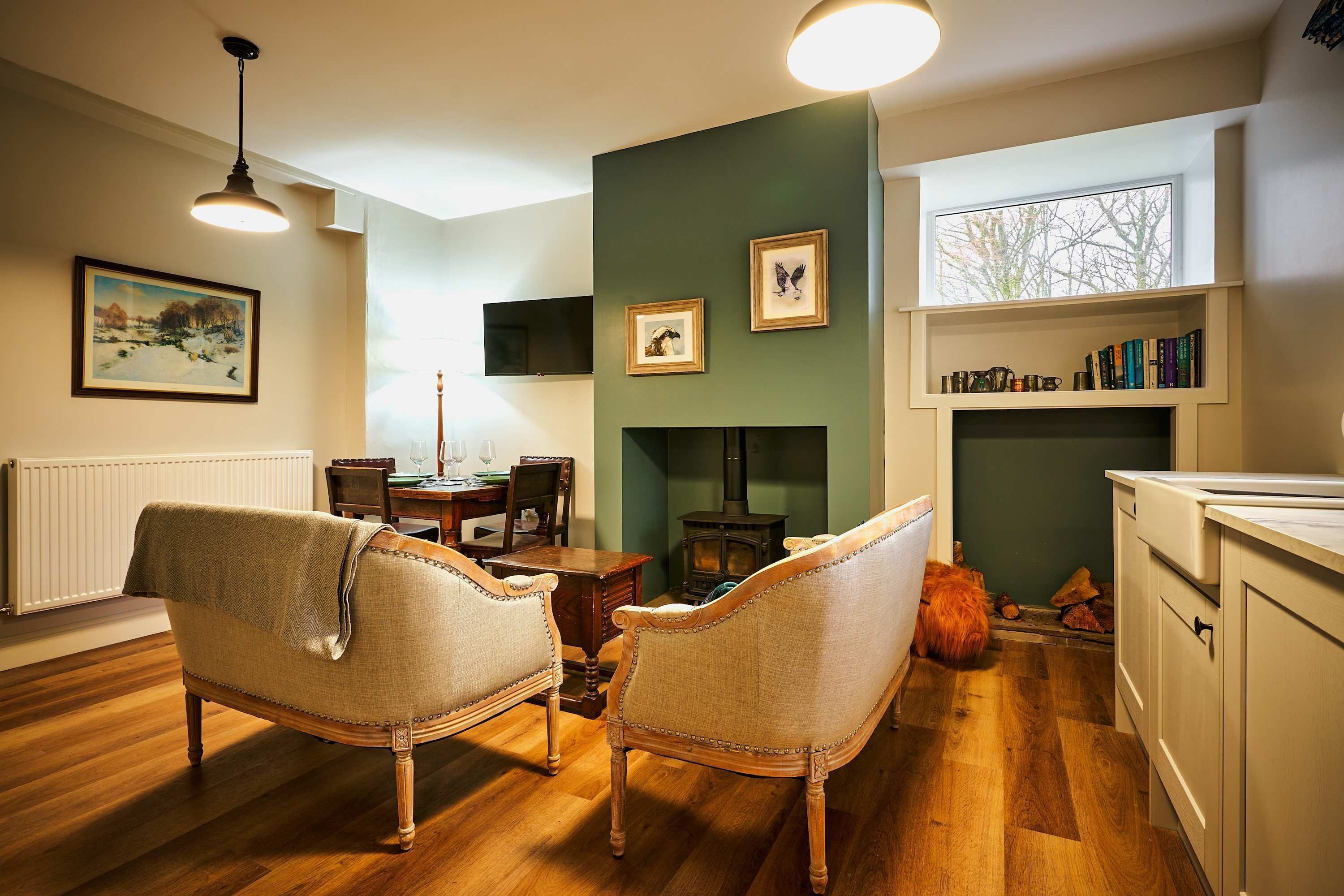 A cozy living room with a fireplace, wooden furniture, and a bookshelf.