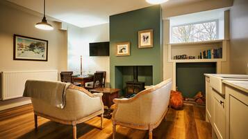 A cozy living room with a fireplace, wooden furniture, and a bookshelf.