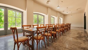 A spacious room with large windows, wooden tables, and chairs arranged for dining. - Kinclune House Buildings on Private Angus Estate (Kirriemuir)